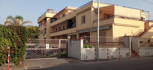 an apartment building with a fence in front of it at Home Tropicana in Mascali
