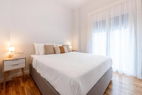Phaedrus Living: Luxury Flat Panormou في أثينا: غرفة نوم بيضاء مع سرير أبيض كبير ونافذة