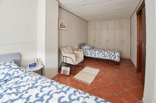 um quarto com uma cama e uma cadeira em L'Alsacien Artiste - Art - Moderne - Wifi - Netflix em Mulhouse