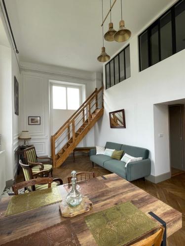 a living room with a table and a couch at VILLA BONVOULOIR in Bagnères-de-Bigorre