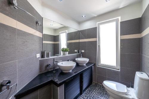 a bathroom with two sinks and two mirrors at Villa of Siam in Ko Chang