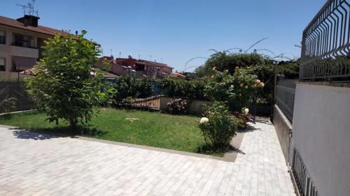 Casa Josè في مارتا: حديقة فيها شجرتين وسياج
