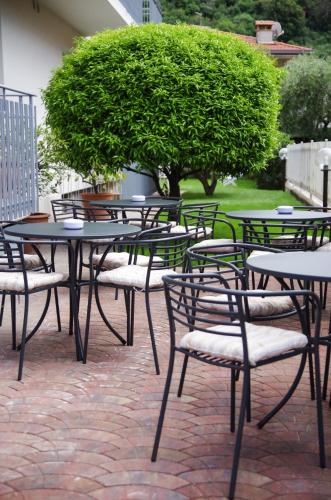 a group of tables and chairs on a brick patio at Hotel Villa Al Vento in Nago-Torbole