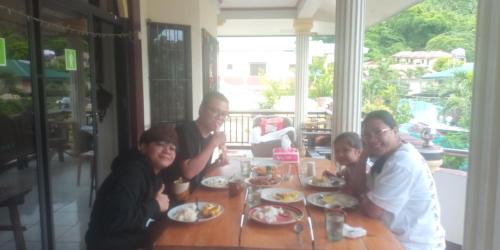 a group of people sitting at a table eating food at Riverside at Aninuan Accommodation and Food in Puerto Galera
