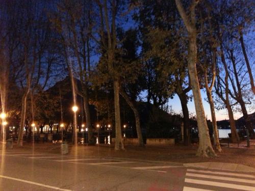 um parque de estacionamento à noite com árvores e luzes em HLL Hotel Lungolago Lecco em Lecco