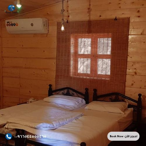 sypialnia z łóżkiem w drewnianym domku w obiekcie Royal Tours Cottages w mieście Umm Lajj