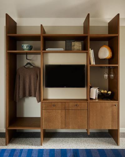 a wooden entertainment center with a television in a room at Morgan & Mees Rotterdam in Rotterdam