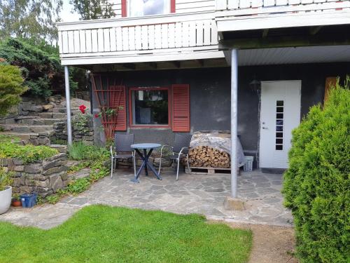 a patio with a table and chairs in front of a house at Krypinn i Søgne in Kristiansand