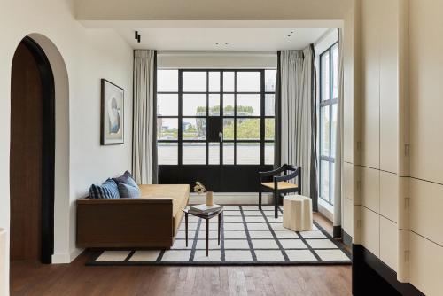 a living room with a couch and a large window at Morgan & Mees Rotterdam in Rotterdam