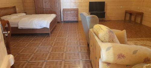 Royal Tours Cottages في أملج: غرفة نوم بسرير وأريكة وأرضية من البلاط