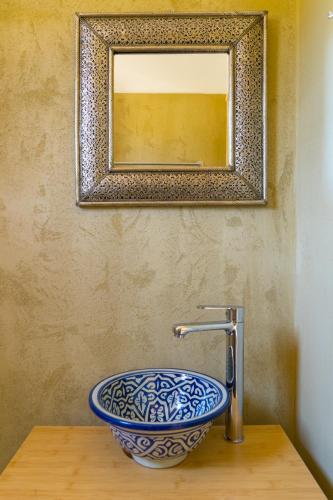 a bathroom with a blue and white sink and a mirror at Exoristoi Nature Suites in Gavdos