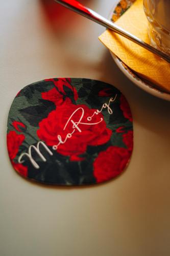 a plate with a red flower on a table at Molo Rouge - Boutiquehotel & Café in Wunsiedel