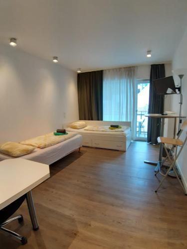 a room with two beds and a table and a desk at LEA-Apartments Zentrum Ost mit Stellplatz in Leipzig