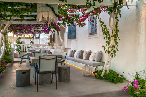 a patio with tables and chairs and flowers at Milos Bay Suites in Adamas