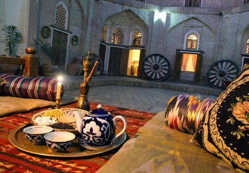 a living room with a tea set on a couch at Amulet Hotel in Bukhara