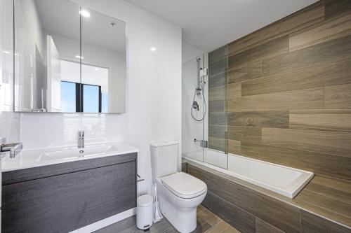 a bathroom with a toilet and a tub and a sink at Liverpool Brand new 2 Br Apt City View Parking in Liverpool