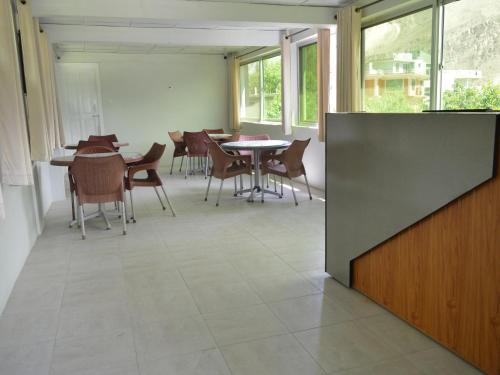 an empty room with tables and chairs and windows at LOKAL Rooms x Hunza Altit Fort in Hunza