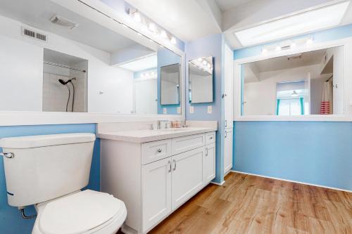 a bathroom with a toilet and a sink and a mirror at Canyon Shores Getaway in Cathedral City