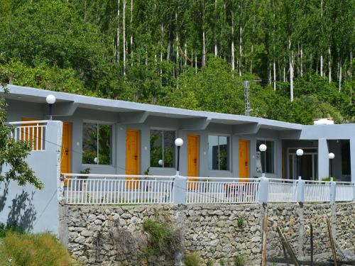 a house with yellow doors and a stone wall at LOKAL Rooms x Hunza Altit Fort in Hunza