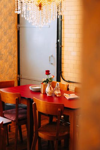 a dining room table with chairs and a red table sidx sidx at Molo Rouge - Boutiquehotel & Café in Wunsiedel