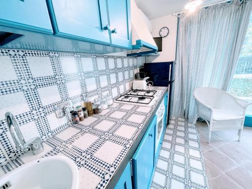 eine Küche mit blau und weiß gefliesten Arbeitsplatten in der Unterkunft Spoleto Splashcasa Piscinaslps 4wifidishwasher - very pretty setting nr pool in Strettura