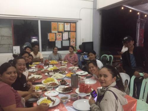 a group of people sitting around a table eating food at Riverside at Aninuan Accommodation and Food in Puerto Galera