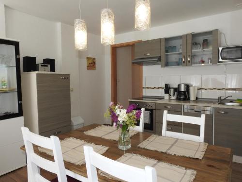 a kitchen with a table with a vase of flowers on it at Ferienwohnungen am Hauptplatz in Pirna