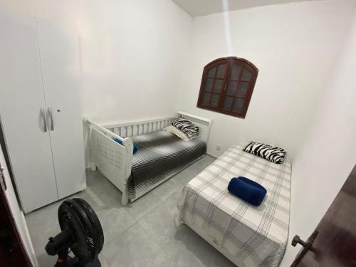 um pequeno quarto com duas camas e um berço em Casa piscina 8 pessoas em Saquarema