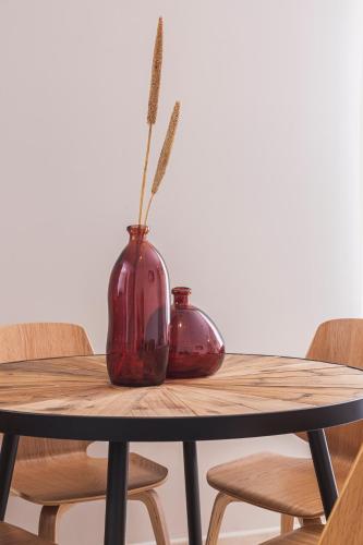 two vases sitting on a wooden table with chairs at Apartamentos Martalia Áticos Deluxe in Ronda