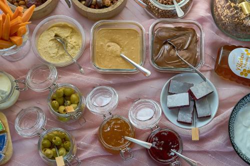 a table topped with containers of food on a pink table at Dolcemente Garni Hotel Superior in Izola