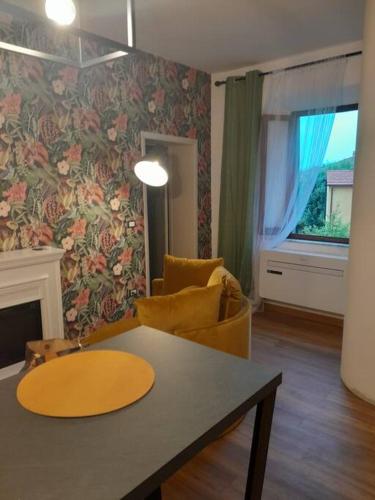 a living room with a table and a chair at Orizzonti Toscani new apartment with view and pool in Laiatico