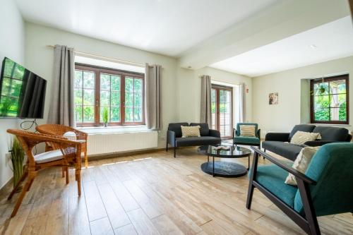 a living room with two couches and a tv at Le Jardin du vieux moulin 6b in Rendeux