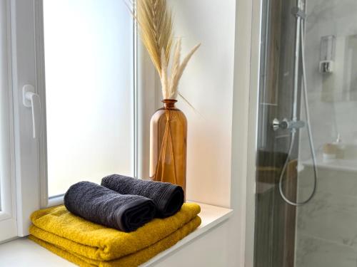 alféizar de la ventana con 2 toallas y un jarrón en Appartement ~ Un Lundi au Soleil~ à 15 min de Lyon, en Miribel