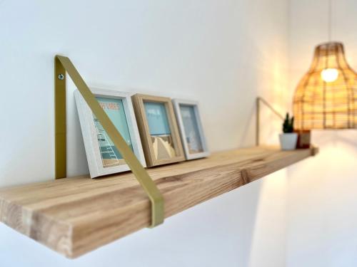 a shelf with three pictures on it in a room at Appartement ~ Un Lundi au Soleil~ à 15 min de Lyon in Miribel