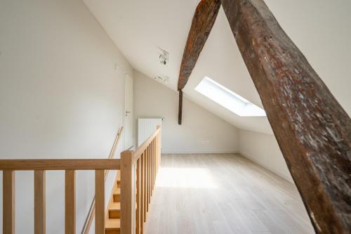an attic room with a staircase and a skylight at Le Jardin du vieux moulin 6b in Rendeux