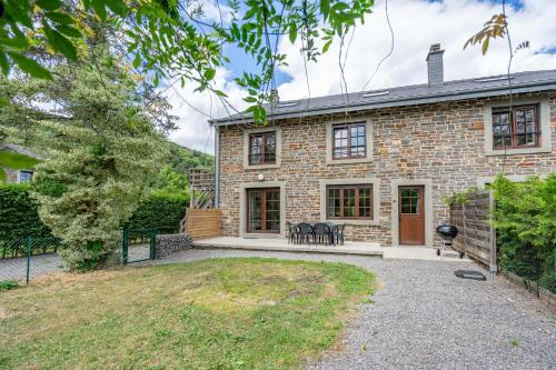 an exterior view of a brick house with a patio at Le Jardin du vieux moulin 6b in Rendeux