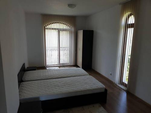 a bedroom with two beds and two large windows at Panoramic Sea View Apartment in Byala