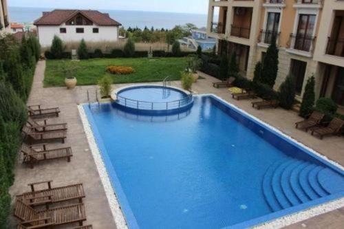 a large blue swimming pool next to a building at Panoramic Sea View Apartment in Byala
