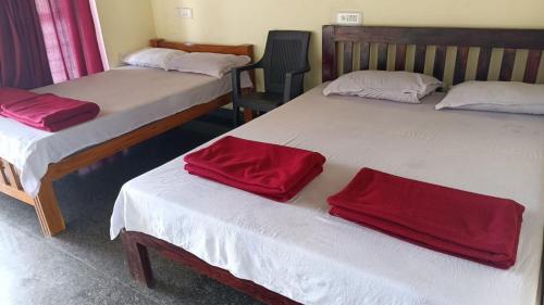 Habitación con 3 camas y toallas rojas. en Gokarna Govekar Beach Stay en Gokarn