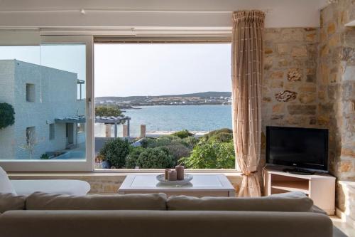 a living room with a couch and a large window at Villa Alkinoi in Kampos Paros