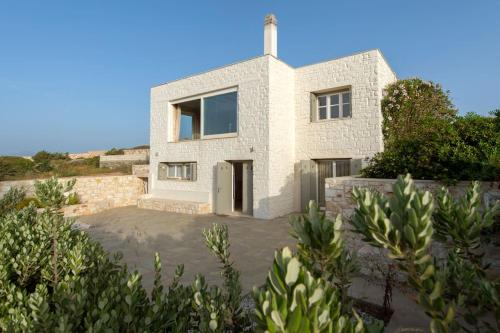 a white house with a cross on top of it at Villa Alkinoi in Kampos Paros