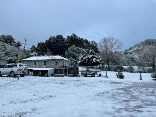 una casa con nieve en el suelo en un patio en Conway River View Cottage For 2, en Cheviot