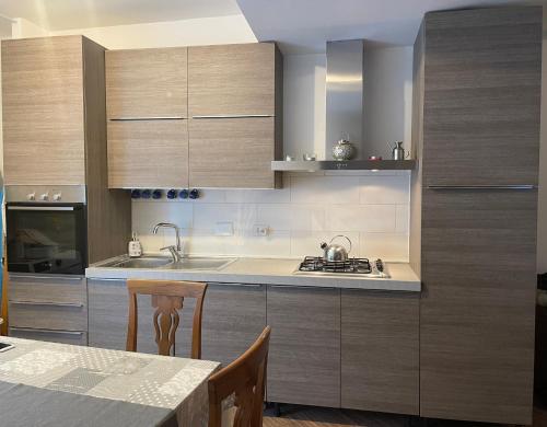 cocina con armarios de madera y mesa de comedor en Appartamento Velletri centro en Velletri