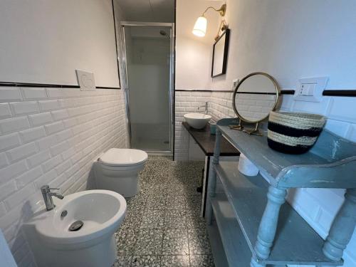 uma casa de banho com um lavatório, um WC e um espelho. em Villa Maria Cristina em Santa Teresa Gallura