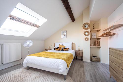 une chambre avec un lit et une lucarne dans l'établissement Les Coulisses - Duplex au centre - Parking privé, à Colmar