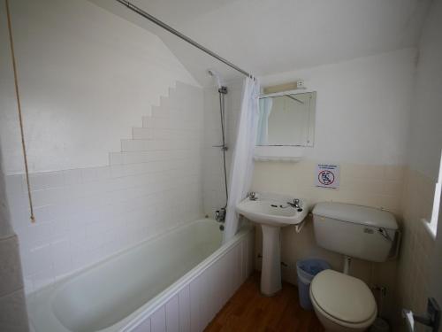 a bathroom with a sink and a toilet and a bath tub at Palm Beach Hotel in Bournemouth
