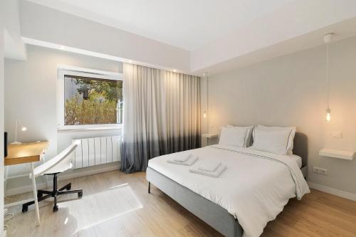 1 dormitorio con cama, escritorio y ventana en Next to the Trees and the Sea, en Estoril