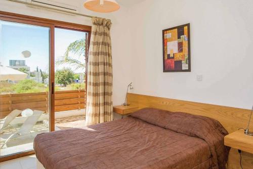 sypialnia z łóżkiem i dużym oknem w obiekcie Coral Olympus Hera w mieście Peja