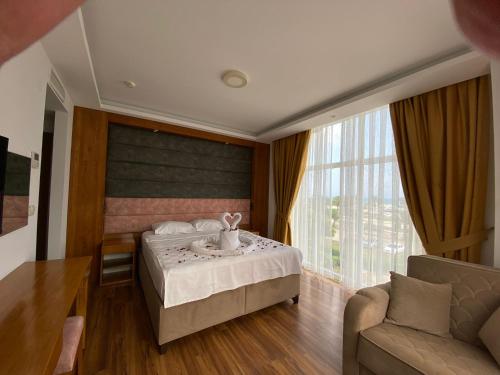 une chambre d'hôtel avec un lit et un canapé dans l'établissement ASKAR PORT OTEL, à Tasucu