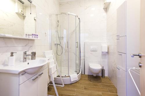 een badkamer met een douche, een wastafel en een toilet bij Apartments Ragusa Palace 1 Djardin in Dubrovnik
